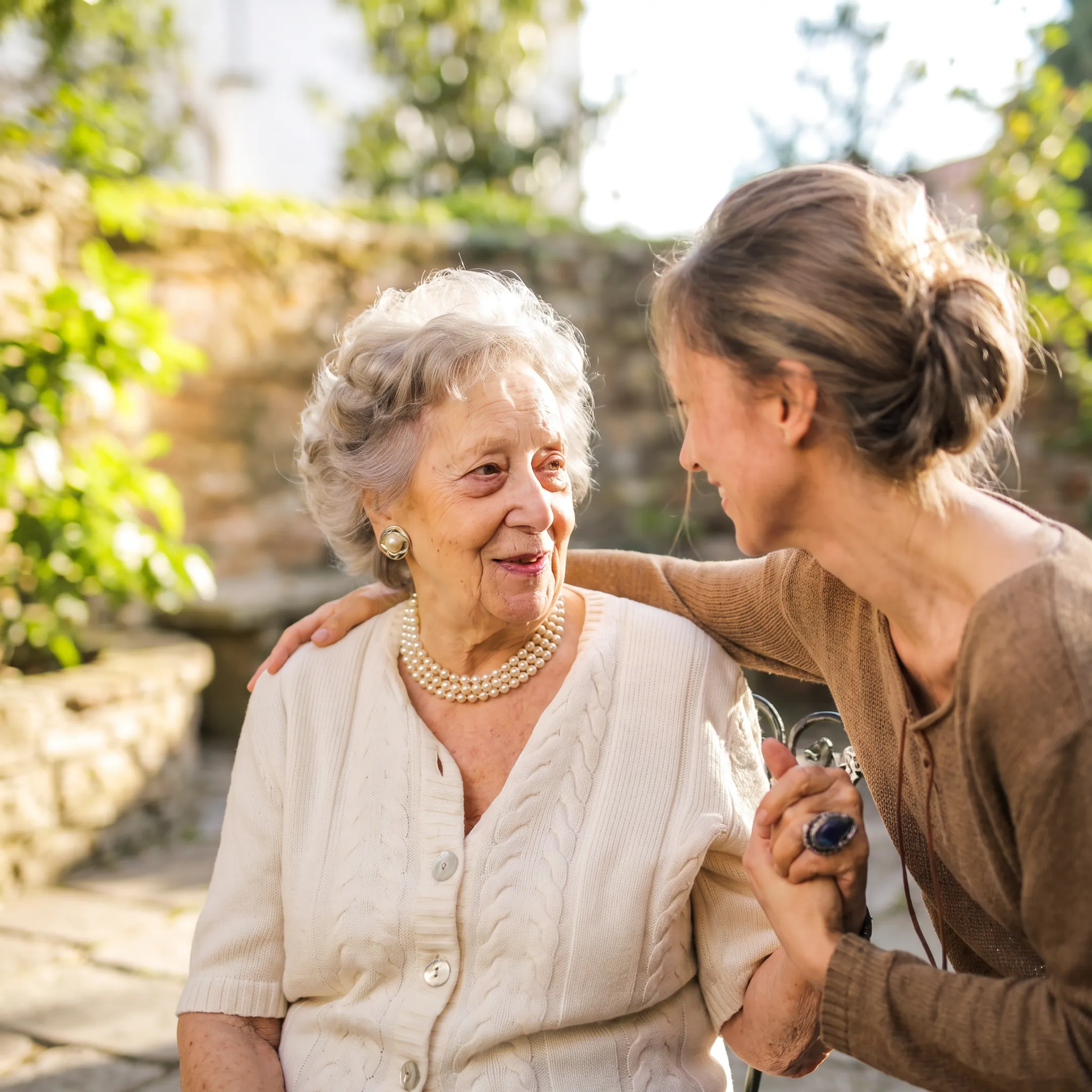 Caregiver supporting an elderly adult in a comfortable living room setting