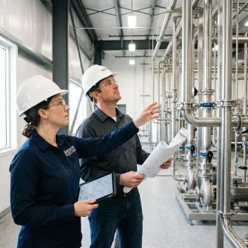 Industrial process piping engineering team reviewing plant systems