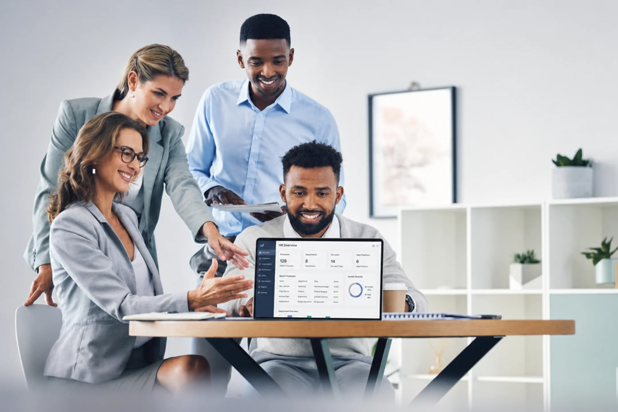 Small business team reviewing HR software dashboard together in office