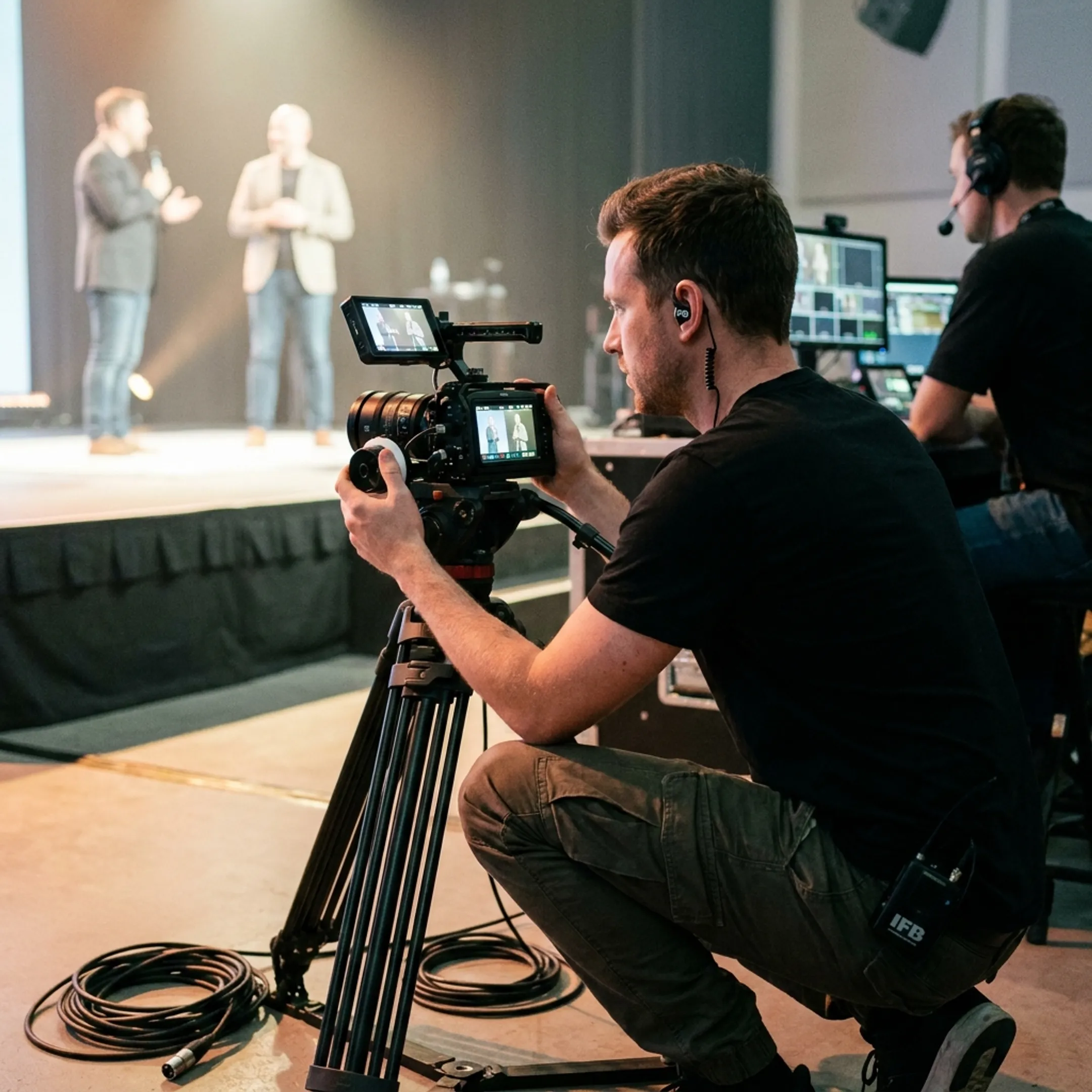 Videographer recording speakers at an event