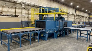 Industrial roller conveyor shot blast machine processing steel plate in production facility