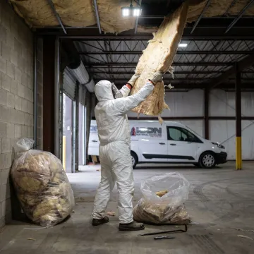 Technician removing insulation in a Michigan commercial facility