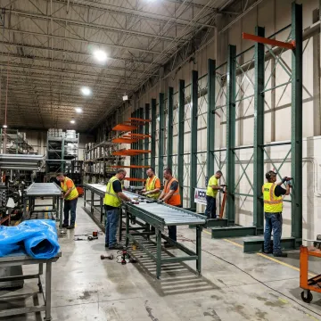 Technicians installing automated warehouse conveyor system