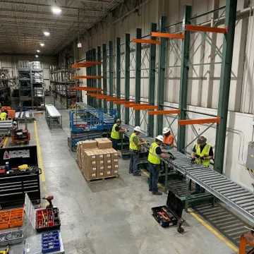 Technicians installing warehouse conveyor automation
