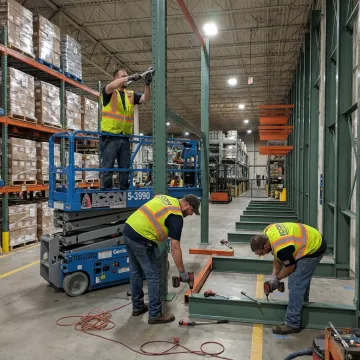Warehouse crew repairing pallet racking