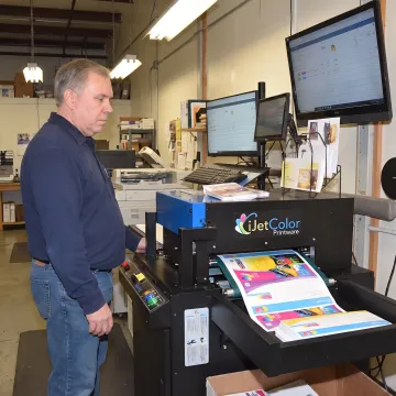 Operator monitoring high-speed digital inkjet printing equipment