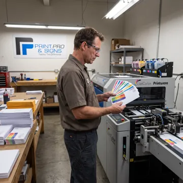 Operator reviewing colorful digital envelope print samples
