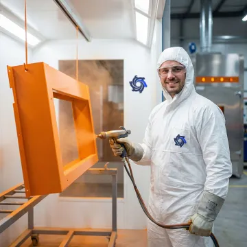 Professional powder coating being applied to industrial metal components in a manufacturing facility
