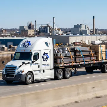 Industrial freight truck transporting manufactured metal components through Milwaukee