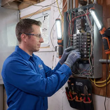 Electrician upgrading an outdated electrical panel to meet current Iowa code requirements