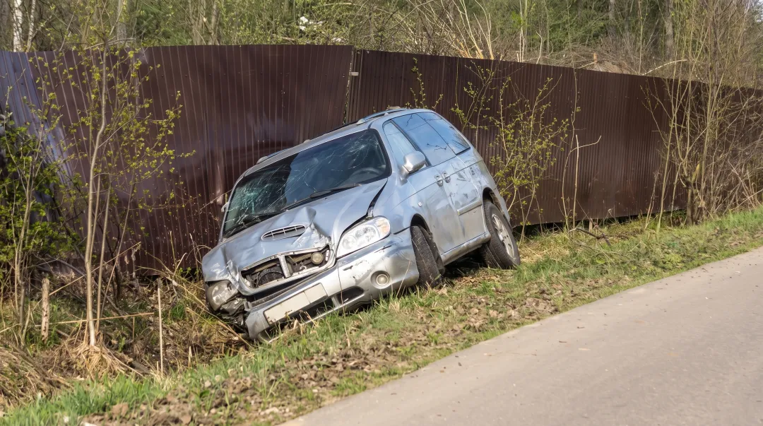 Damaged car after collision accident on rural highway roadside