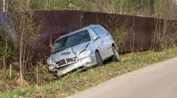 Damaged car after collision accident on rural highway roadside