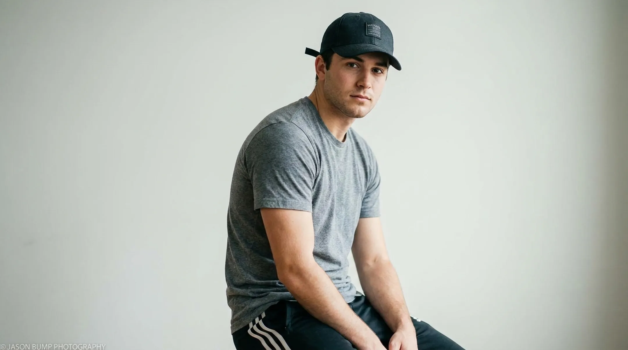 Model wearing baseball cap styled with casual athletic wear