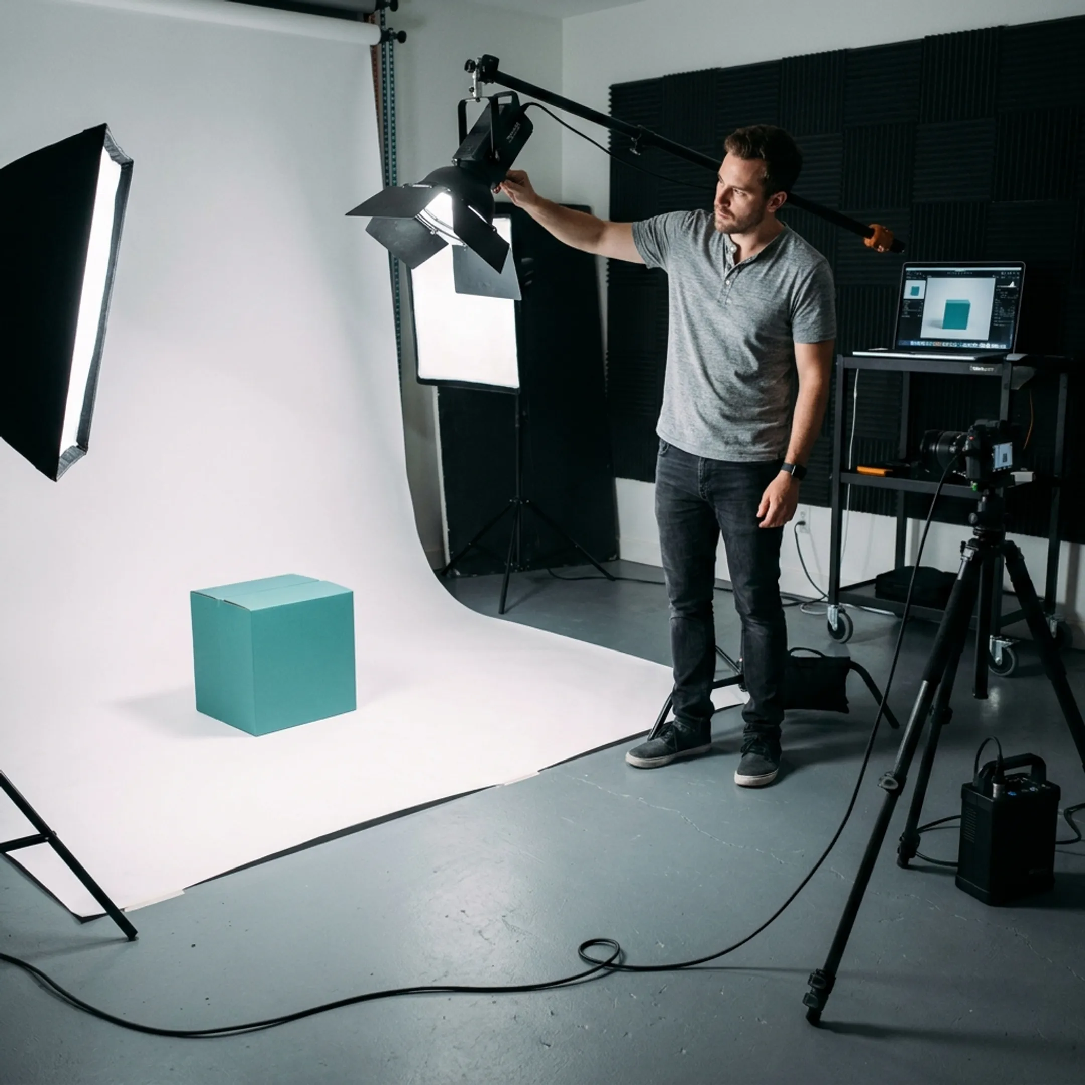 Commercial photographer adjusting studio lighting on product setup