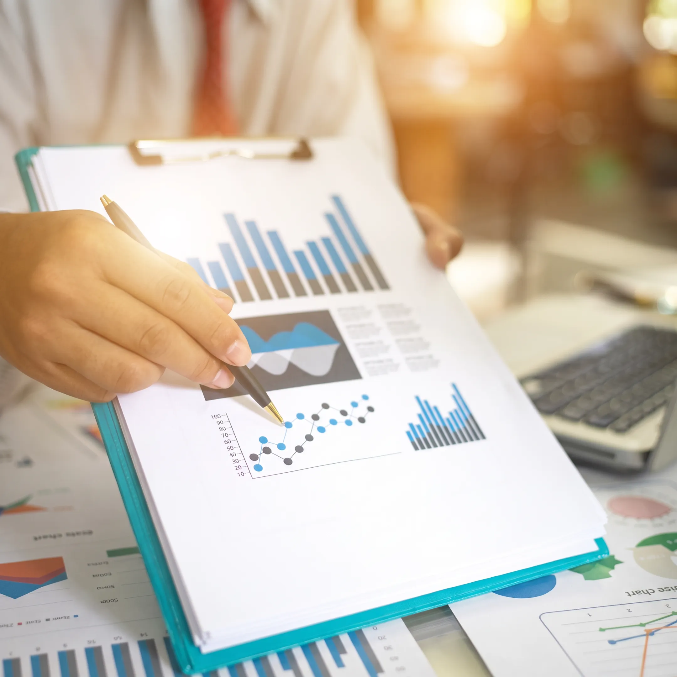 Professional reviewing bookkeeping reports with business records and laptop