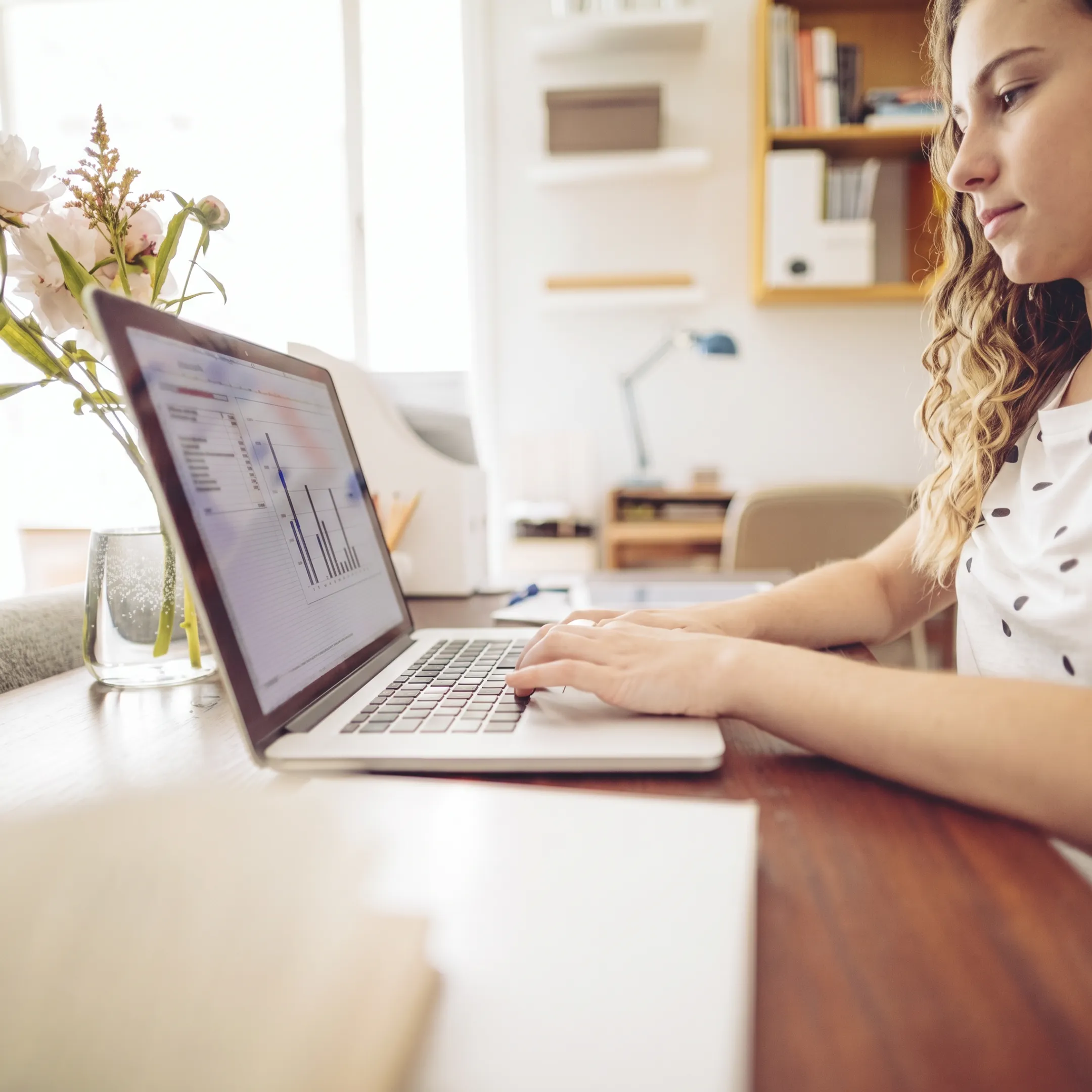 Bookkeeper reviewing organized business financial records at a desk