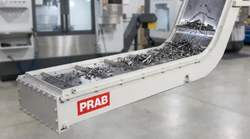 Magnetic conveyor system transporting ferrous metal chips and scrap at incline