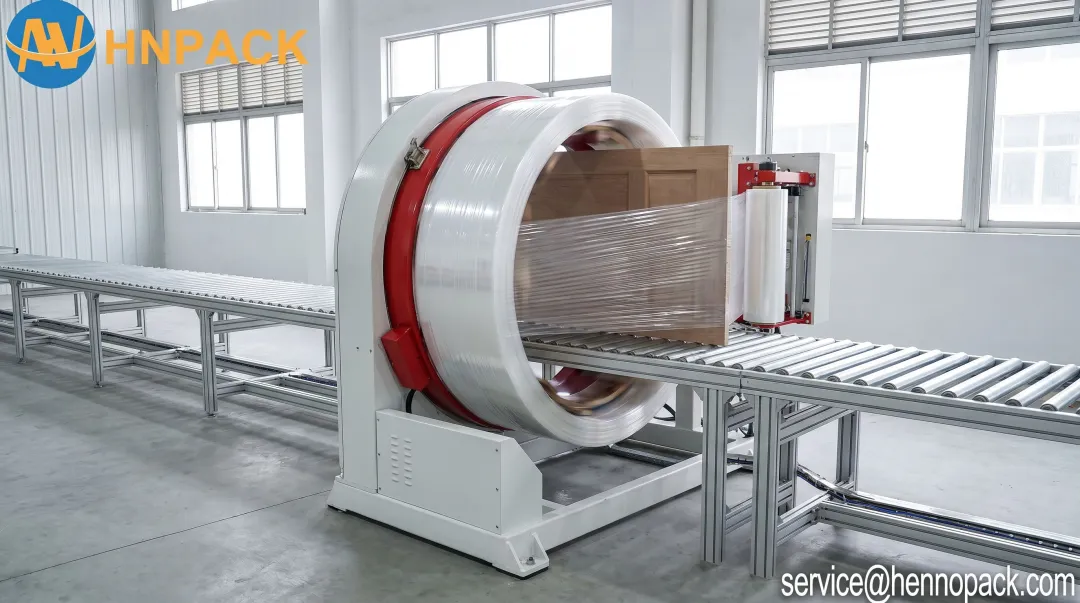 Orbital wrapper applying stretch film around window assembly on production conveyor line