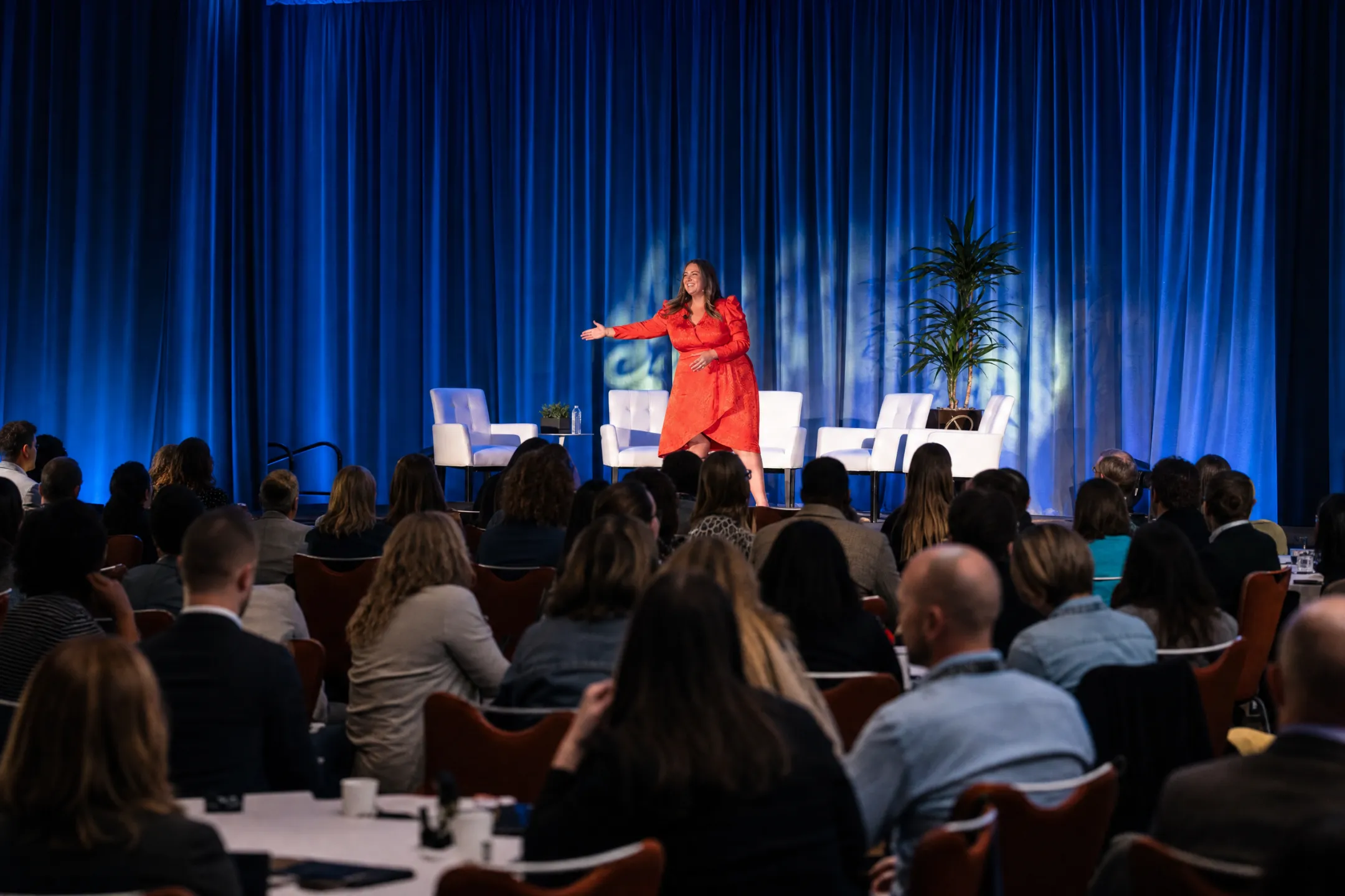 Keynote speaker presenting confidently on stage to corporate audience