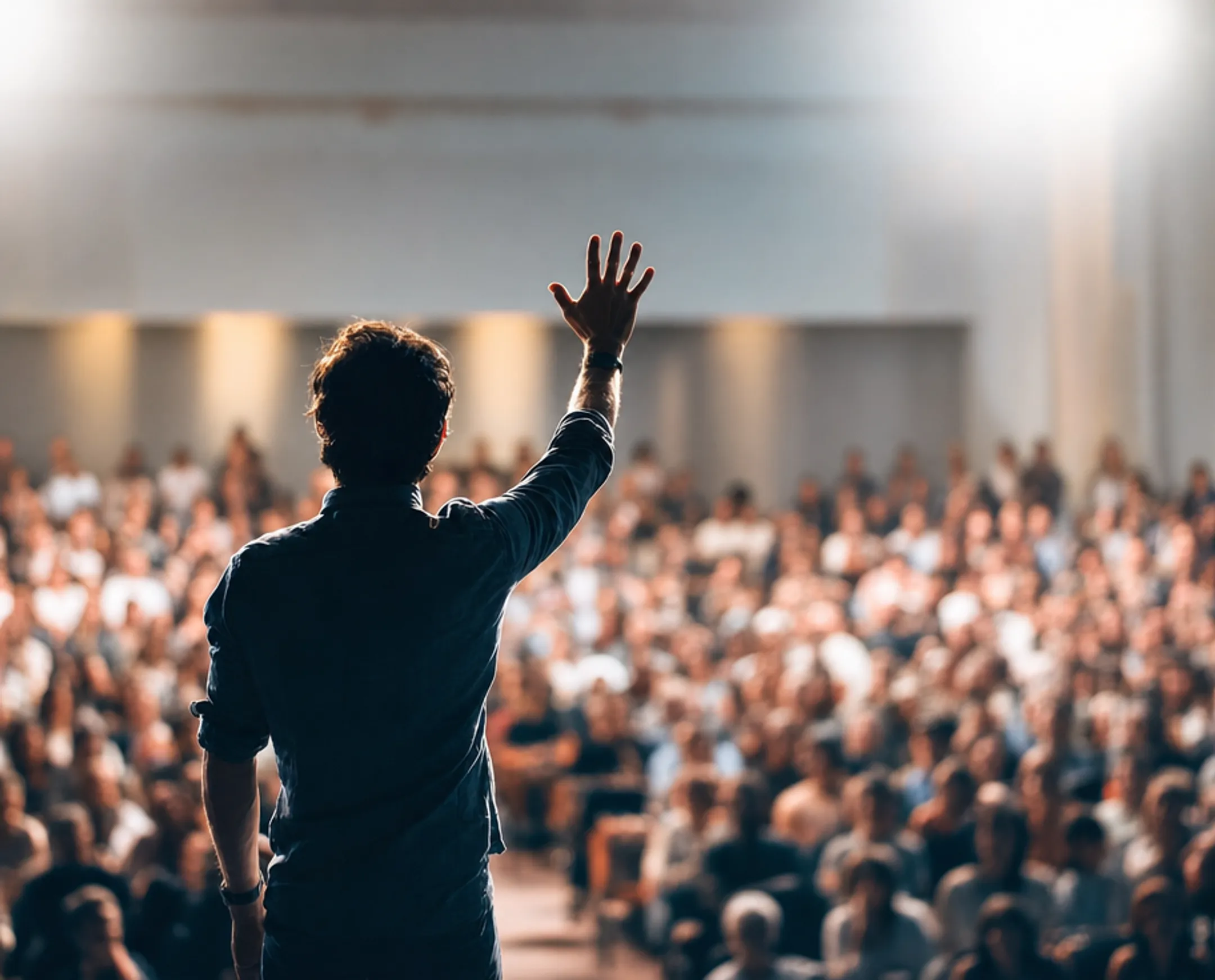 Motivational keynote speaker performing on stage before corporate audience
