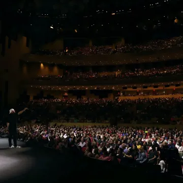 Jon Dorenbos speaking on stage at a corporate keynote event