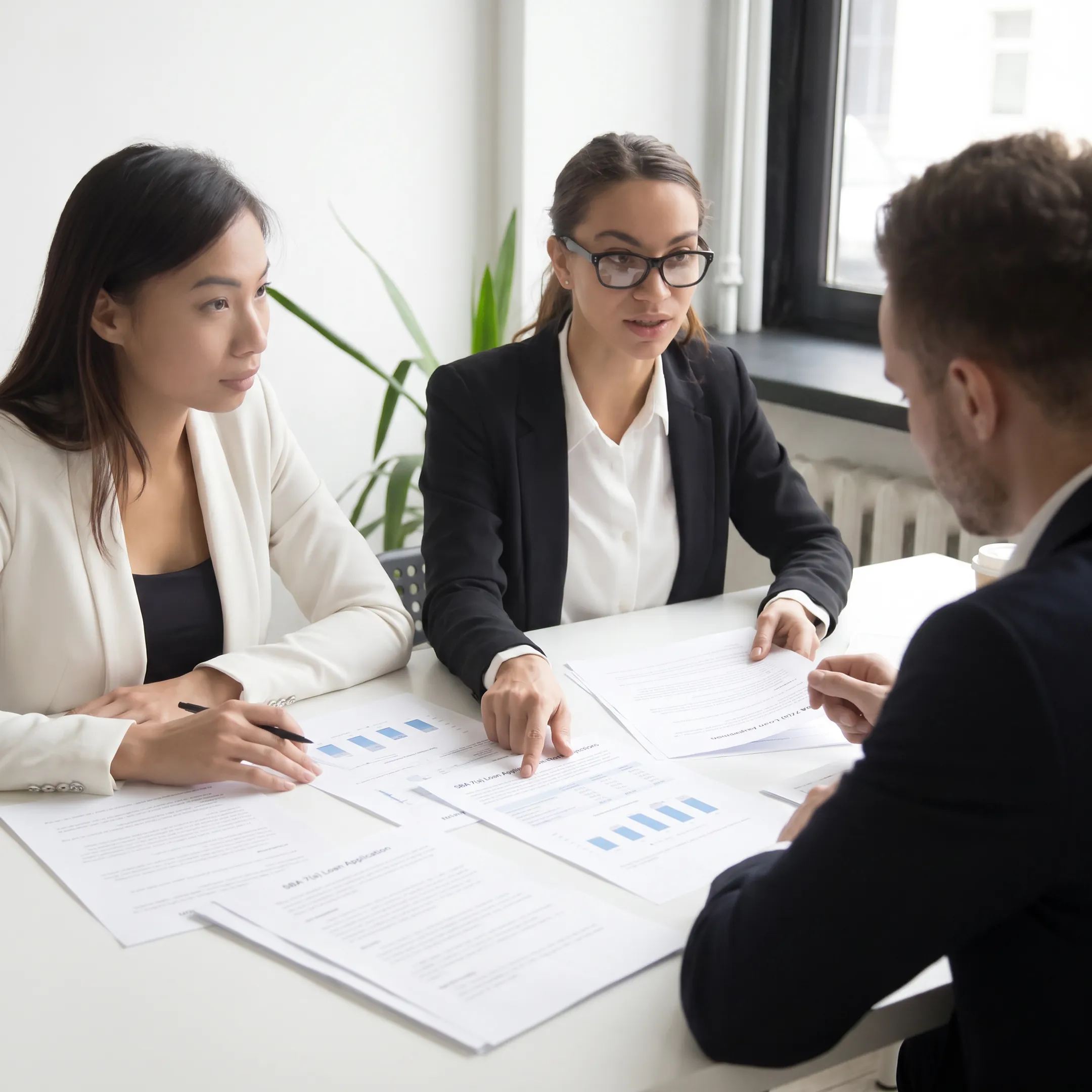Business owners reviewing expansion financing documents with a financial advisor