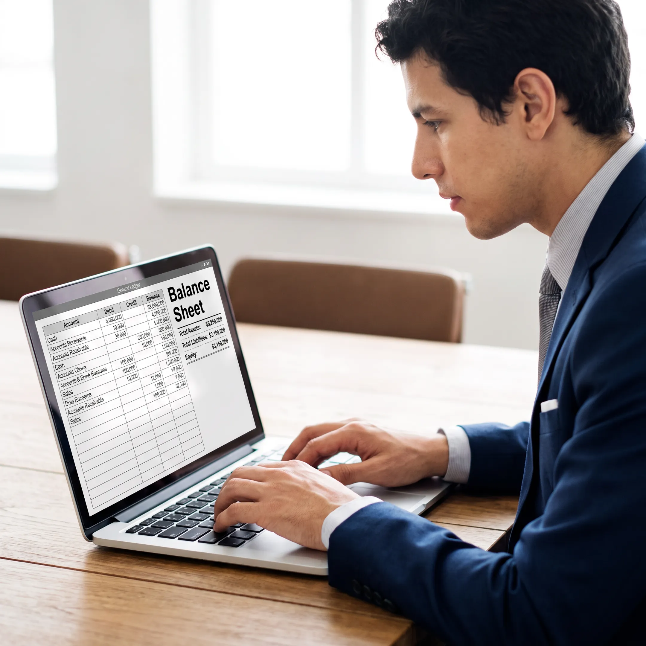 Accounting specialist performing balance sheet reconciliation on a laptop