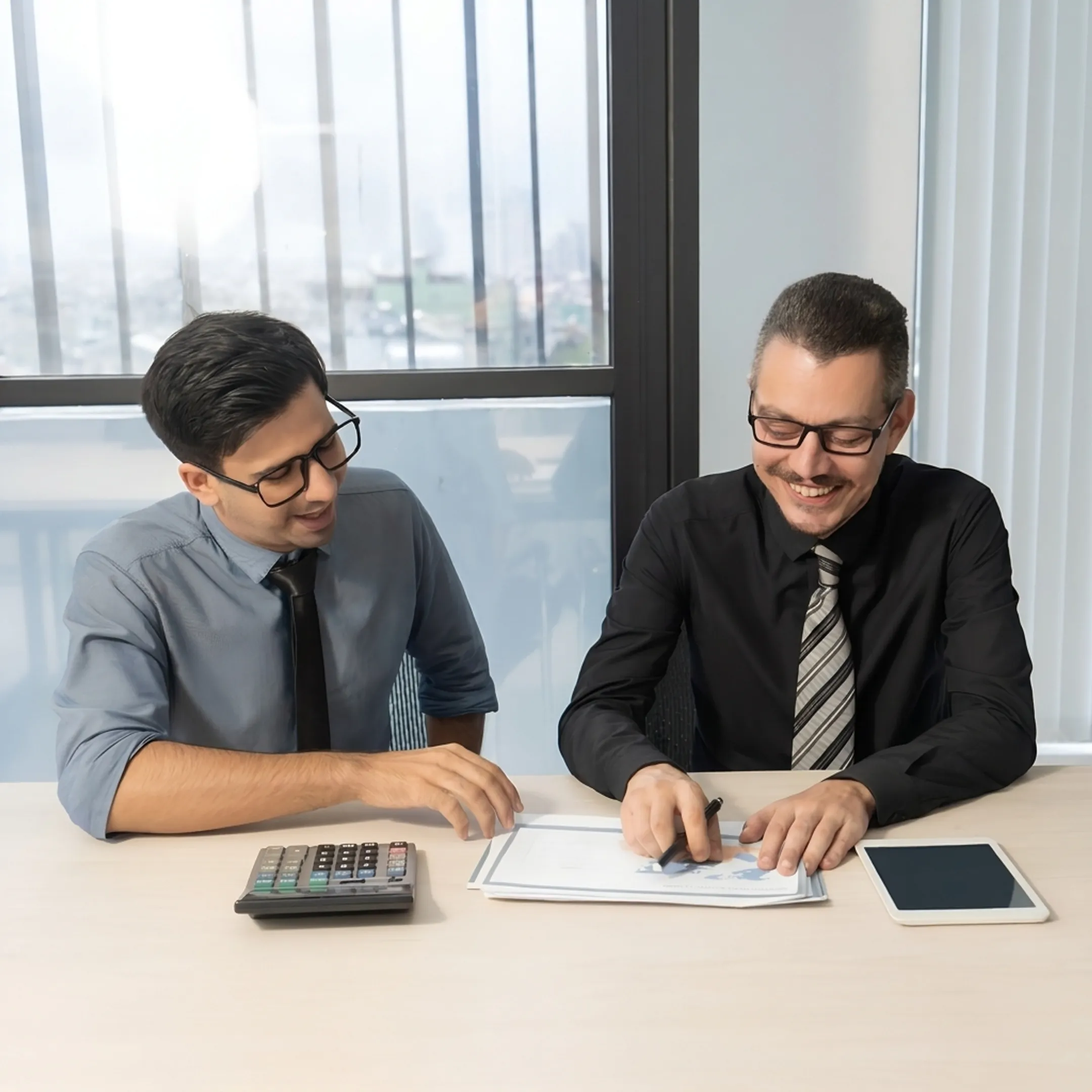 Advisor reviewing tax compliance paperwork and financial information with a business client