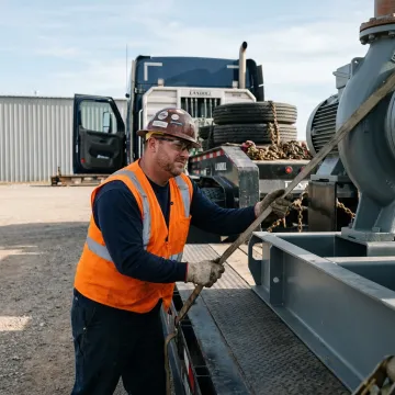 Heavy haul driver inspecting oversized equipment before transport