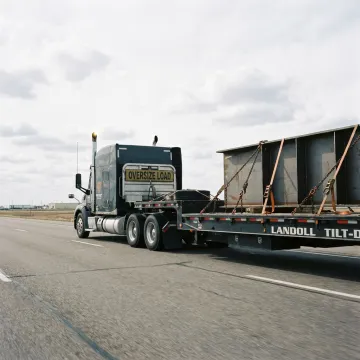 Flatbed truck hauling heavy equipment