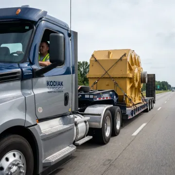 Heavy haul flatbed truck carrying oversized equipment