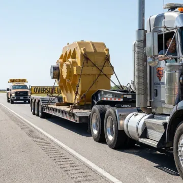 Heavy haul flatbed truck transporting oversized machinery