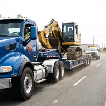Heavy equipment hauling truck transporting excavator in Sacramento