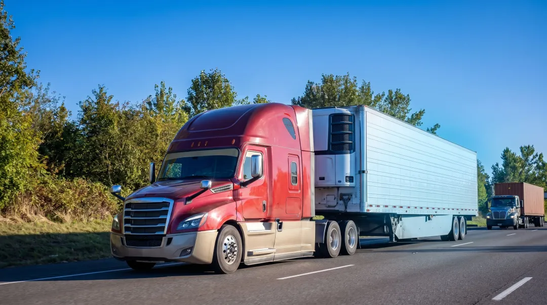 Specialized refrigerated freight truck on highway representing complex reefer carrier operations
