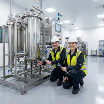 Professional technicians installing industrial filtration equipment in manufacturing facility