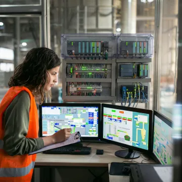 Advanced PLC control panel with industrial automation equipment in modern manufacturing facility