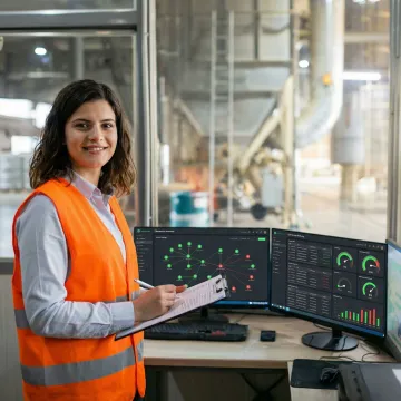 Engineer reviewing industrial cybersecurity dashboard with network topology and security status