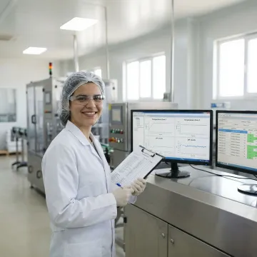 Food production engineer monitoring automated control systems on digital displays