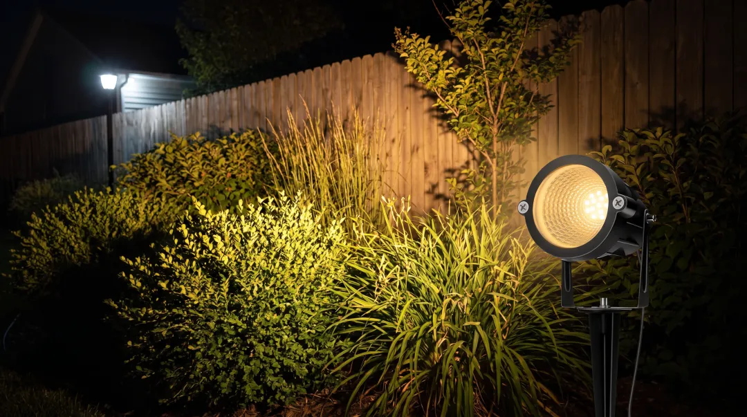 Warm tunable LED landscape light illuminating garden path at dusk