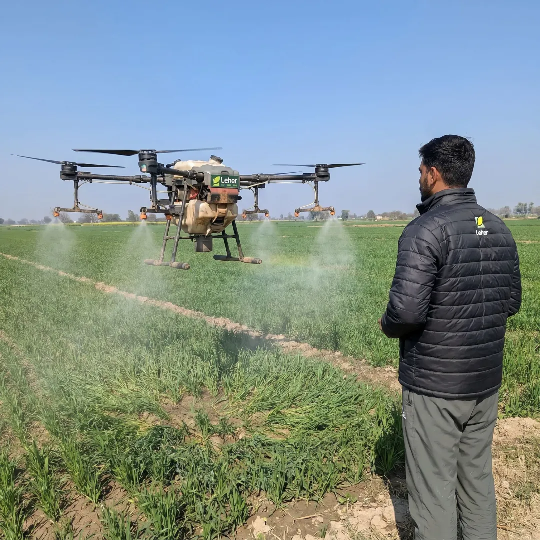 Agriculture spraying drone flying over crop field