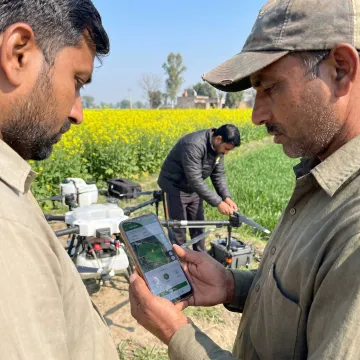 Farmer booking drone spraying through an app