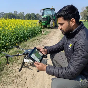 Drone pilot preparing an agriculture drone for spraying
