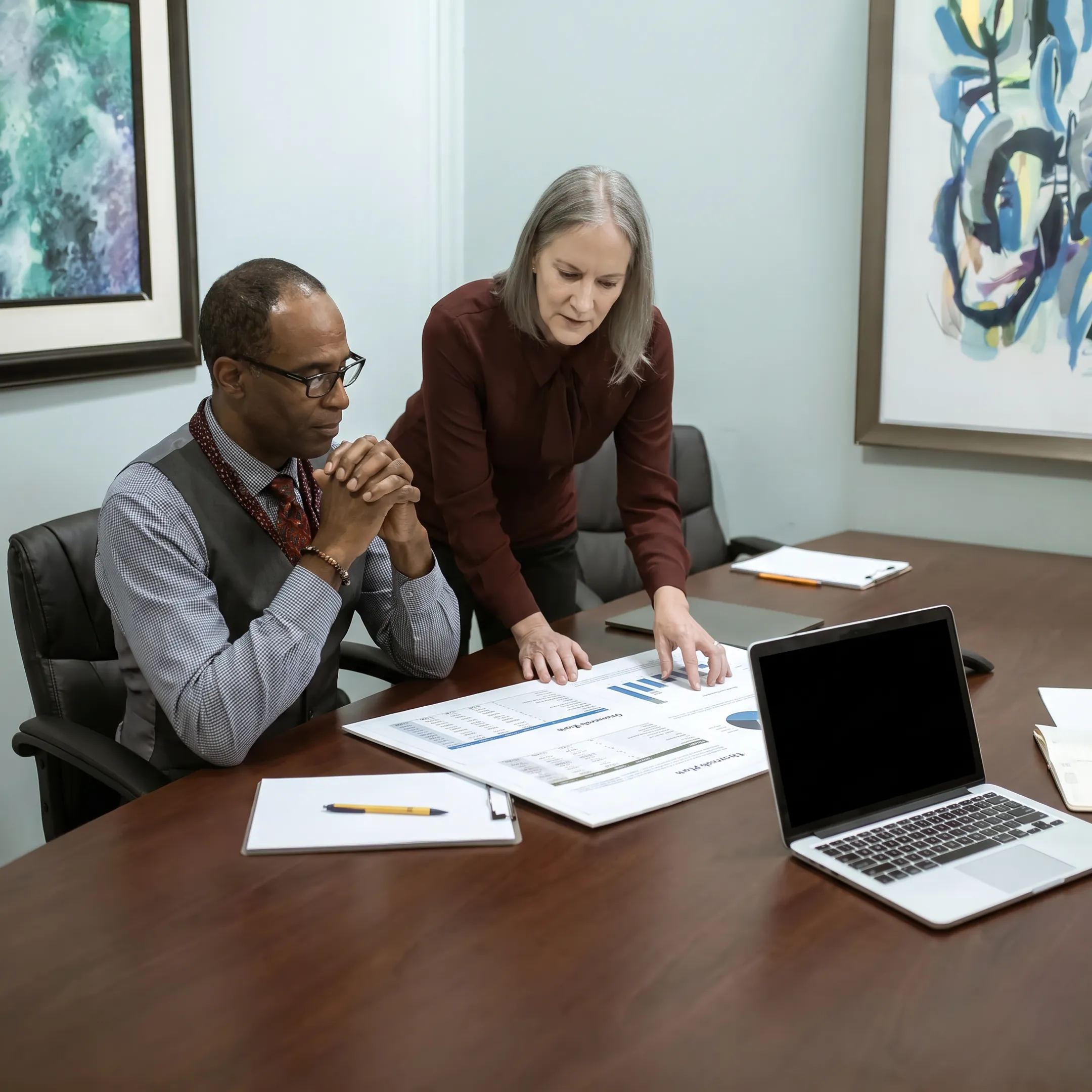 Veteran entrepreneur reviewing business financing documents with a funding specialist