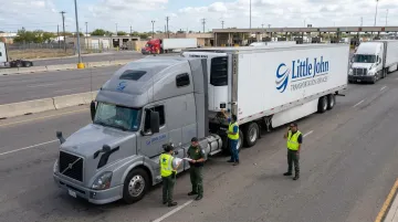 Pharmaceutical cold chain carrier team at US-Mexico border crossing with temperature-controlled trailer