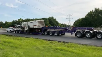 Heavy haul multi-axle lowboy trailer transporting large industrial machinery on highway