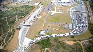 Commercial freight trucks queued at busy US-Mexico border crossing checkpoint