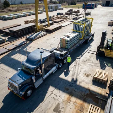 Flatbed trailer being loaded with industrial equipment