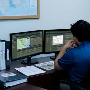 Logistics team monitoring secure military freight shipment