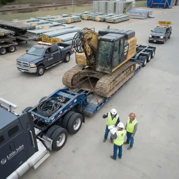 Heavy equipment being loaded onto a specialized trailer