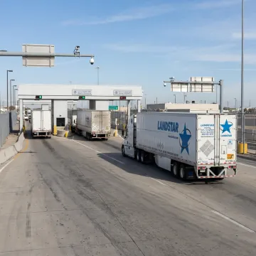 Cross-border freight truck approaching a border facility